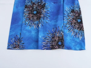 Dettaglio dell'orlo dell'abito blu senza maniche con motivo di fuochi d'artificio