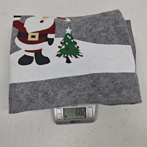 Detailed weight measurement showing a 68.2g grey felt Christmas chair cover on a scale