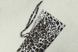 Detailed macro view of thin leopard print fabric texture and matching tie-up string detail