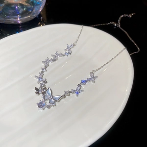Detail of silver butterfly pendant necklace with zircon and mother of pearl on ceramic