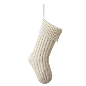 Classic cream knitted Christmas stocking with decorative tassels and hanging loop on white backdrop