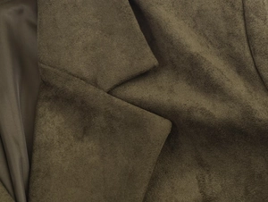 Detailed close-up of olive green suede blazer lapel showing fine texture and sewing