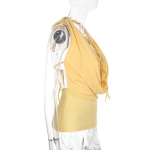 Seitenansicht des gelben rückenfreien Neckholder-Tops aus dehnbarem Strick auf transparentem Model