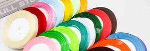 Close-up of colorful 1cm satin ribbon rolls for gift wrapping and DIY crafts decor