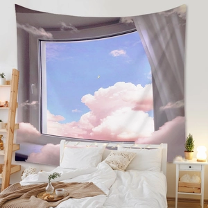 Cozy bedroom setting with tapestry showing pink clouds and moon scenery over a bed