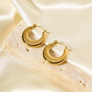 Boucles d'oreilles lune dorées en forme de U sur pierre avec fond de soie luxe
