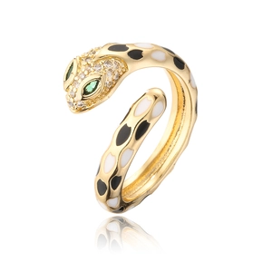 Macro detail of gold-plated snake ring with enamel spots and green crystal eyes
