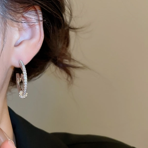 Close-up of 18K gold plated hoop earrings with micro-set cubic zirconia on a model