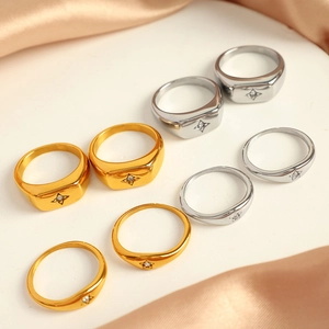Minimalist 18k gold and silver rings with star-shaped zircon inlays on satin backdrop