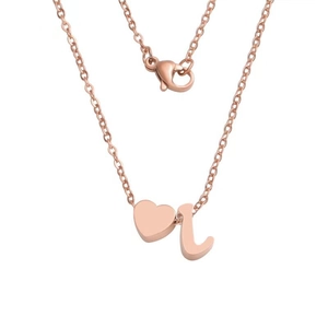 Detail of rose gold stainless steel necklace featuring a heart charm and cursive letter L