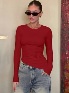 Haut moulant rouge à manches longues et col rond avec un jean bleu classique pour femme