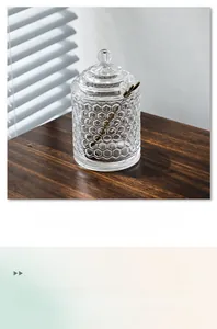 Detailed close-up of a honeycomb glass candy jar with elegant gold leaf metal spoon