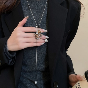 Detailed view of silver horse pendant necklace with tiger eye stone worn on dark outfit