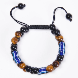 Détail de perles œil de tigre 8mm et breloque œil bleu sur bracelet tissé réglable