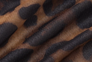 Macro shot of semi-transparent leopard print mesh fabric showing fine knit texture