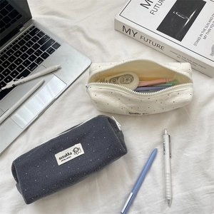 Detailed close-up of polka dot wool stationery pouches with smooth zipper and brand label