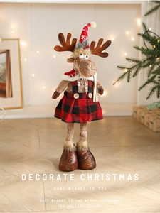 Close-up of Christmas reindeer plush doll in red plaid skirt for festive home decoration