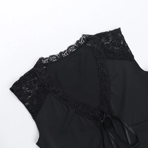 Close-up of black lace patchwork fabric and satin ribbon tie on women top