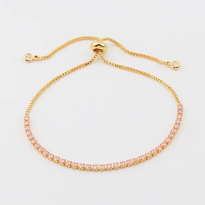 Detail of pink square-cut zircon tennis bracelet with adjustable golden bolo clasp