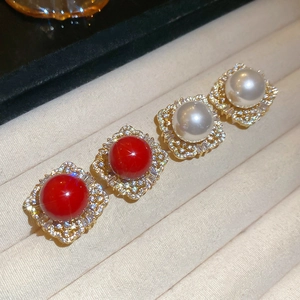 Detail view of vintage square stud earrings with zircon inlay and pearls on a velvet tray
