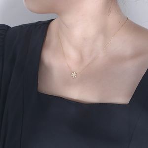 Elegant 925 sterling silver snowflake pendant necklace with gold finish on female model