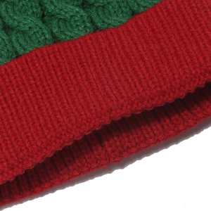 Close-up of red and green knitted Christmas hat with chunky cable stitch patterns