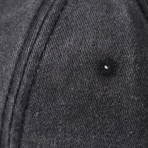Close-up of charcoal washed cotton twill fabric with precision stitching and ventilation eyelet