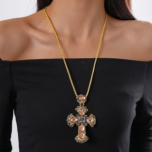 Close-up of a vintage luxury gold cross pendant necklace with sparkling inlaid gemstones