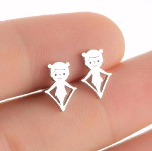 Macro shot of miniature stainless steel figure earrings held between fingers for scale