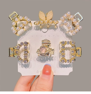 Detail of 6 mini gold hair claws with pearls and rhinestones on branded card