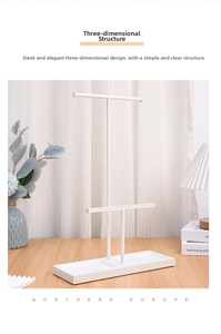 Detail of white metal jewelry stand with T-bars and wooden tray in minimalist setting