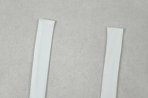Detail shot of white fabric halter neck ties with high-quality stitching and texture