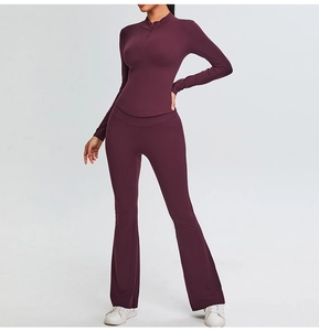 Detail view of high-waist flared yoga pants and slim-fit long-sleeve top in deep burgundy