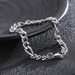 Bracciale a catena Figaro in argento lucido per uomo e donna su vassoio nero minimalista