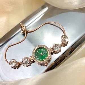 Detail of adjustable rose gold bracelet watch with green dial and rhinestones on satin