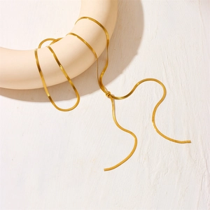 Adjustable gold flat snake chain necklace with slider bead buckle on a minimalist display
