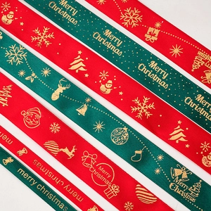 Christmas ribbons with gold foil Merry Christmas prints, bells, and snowflakes on satin