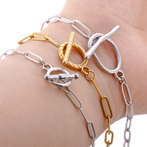 Close-up of 18k gold and silver stainless steel bracelets with creative OT toggle clasp