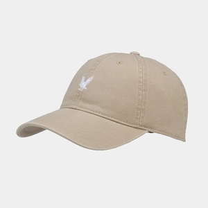 Close-up of white eagle embroidery on khaki cotton baseball cap with curved brim
