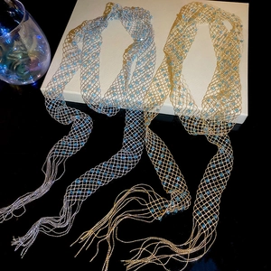 Close-up of gold and silver mesh fringe necklaces with light blue bead details