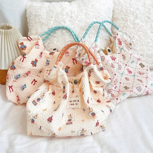 Detail of seersucker canvas tote bags featuring cute cartoon prints and snap buttons