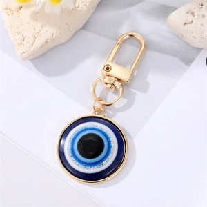 Blue Evil Eye keychain with gold alloy frame and lobster clasp on white background