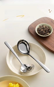 Close-up of polished 304 stainless steel soup ladle with rounded edges in a ceramic bowl