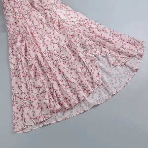 Détail de l'ourlet de robe longue fleurie rose avec volants délicats et tissu en mousseline