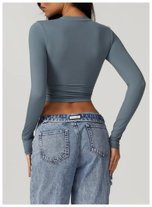 Rear view of a slim-fit gray cropped yoga top paired with light blue washed denim jeans