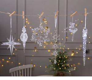 Clear acrylic Christmas ornaments hanging on a wooden string with warm festive lighting