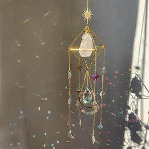 Detail of golden crystal suncatcher featuring a natural stone and rainbow prism pendant