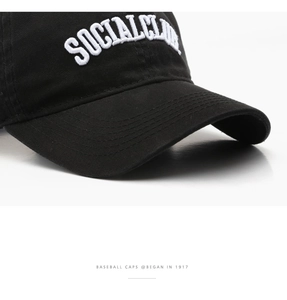 Dettaglio del ricamo bianco SOCIALCLUB su un berretto da baseball in cotone nero