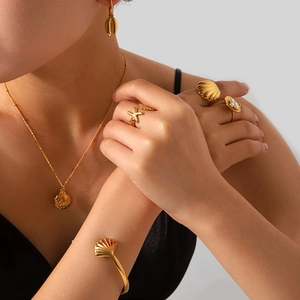 Golden ocean jewelry set featuring starfish ring and shell pendant necklace on model