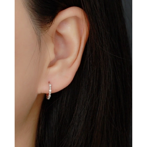 Close-up of S925 sterling silver hoop earrings with inset zircons on a female model
